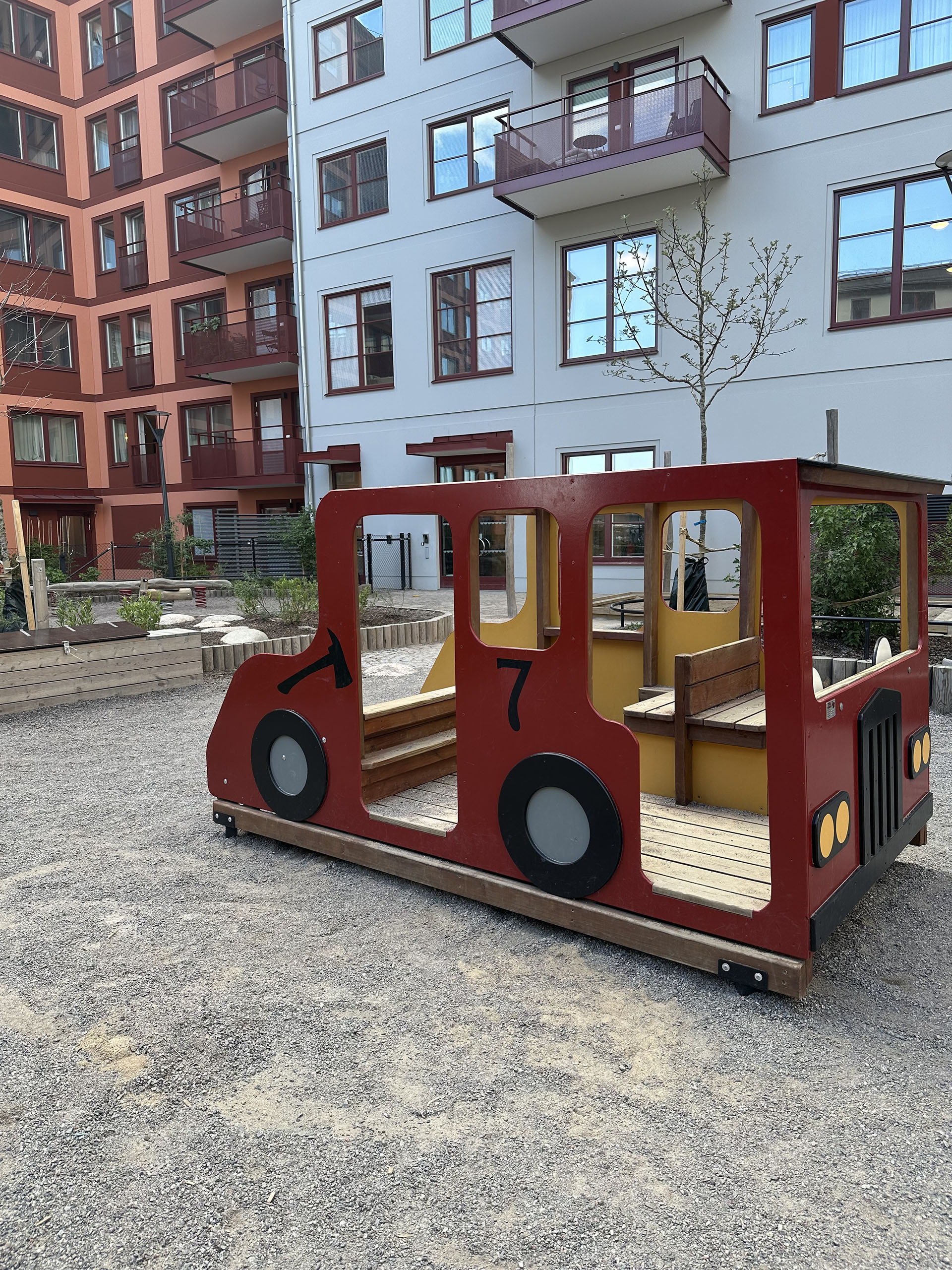 En gård med lekredskap i form av ett tåg.