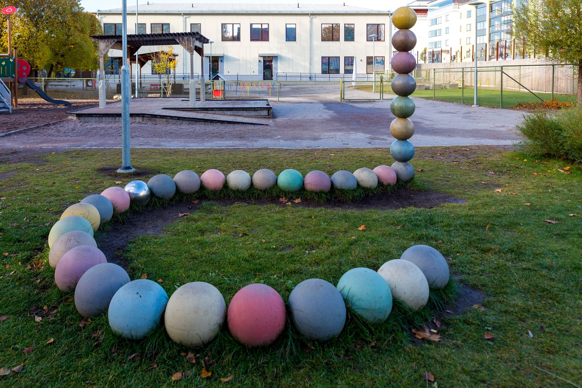 Gård med lekhus, sandlåda, klätterställning med mera samt hus i bakgrunden.