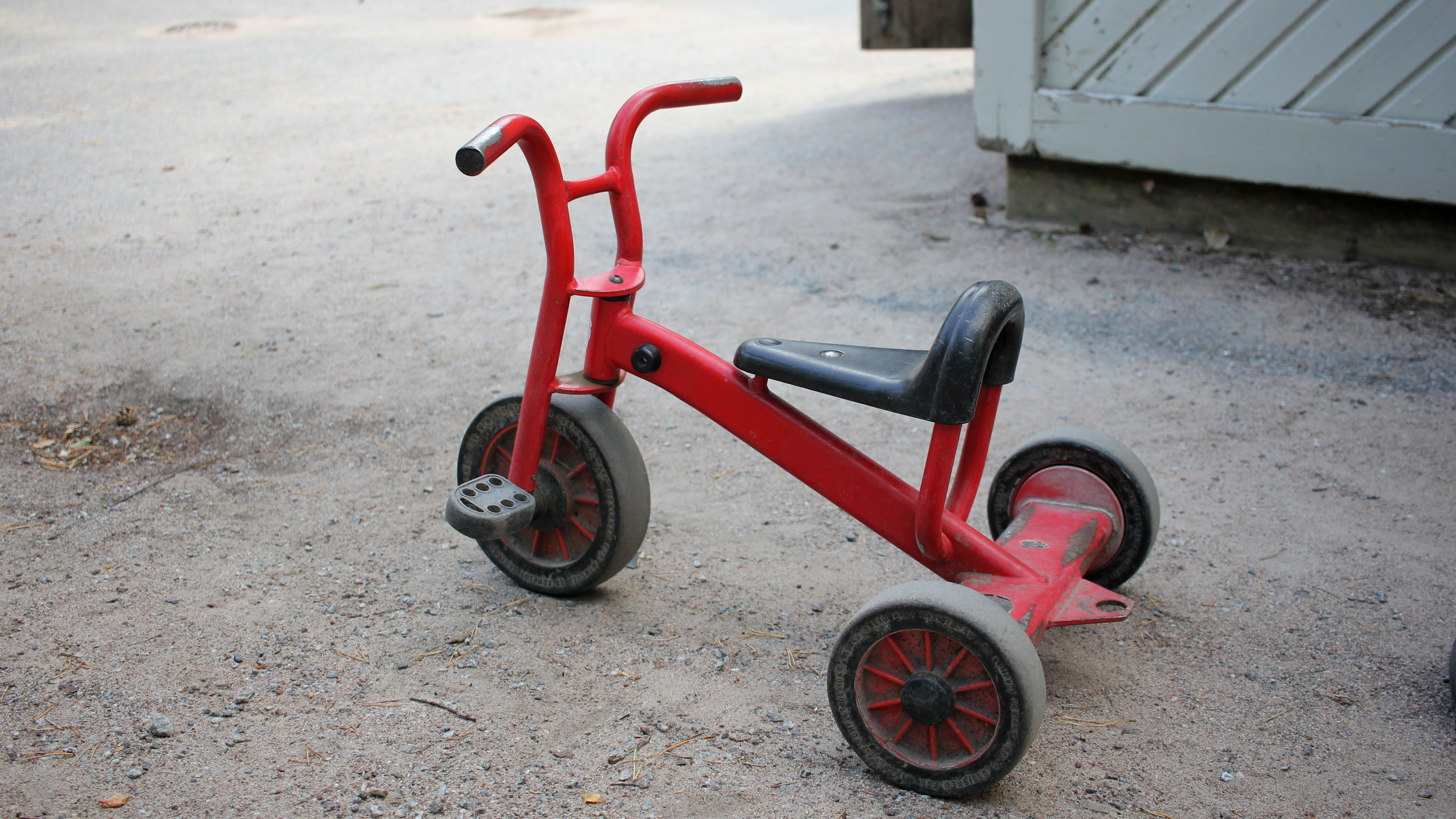 Röd cykel för små barn på en grusgång.