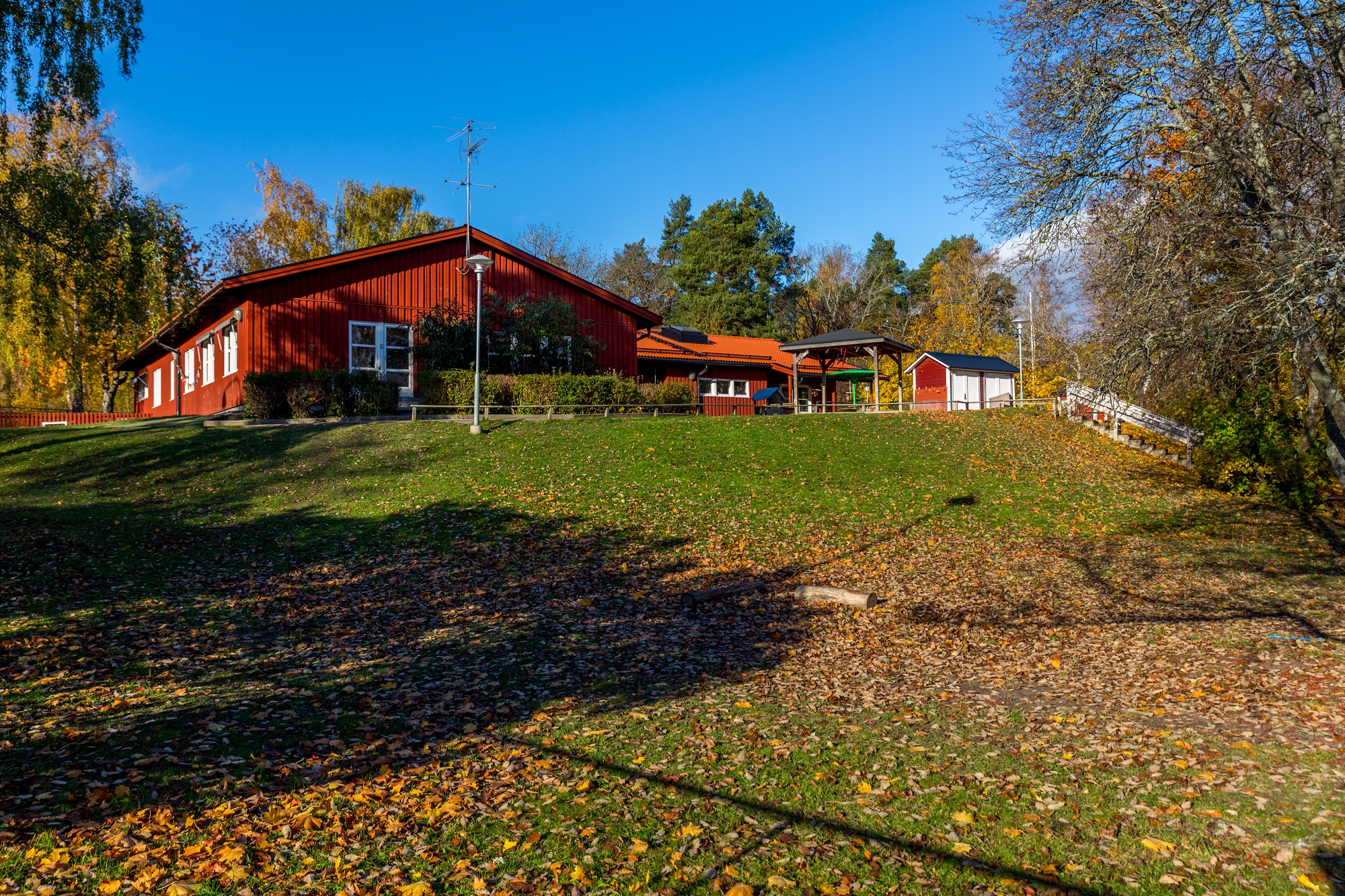 Byggnad på en kulle med träd i bakgrunden