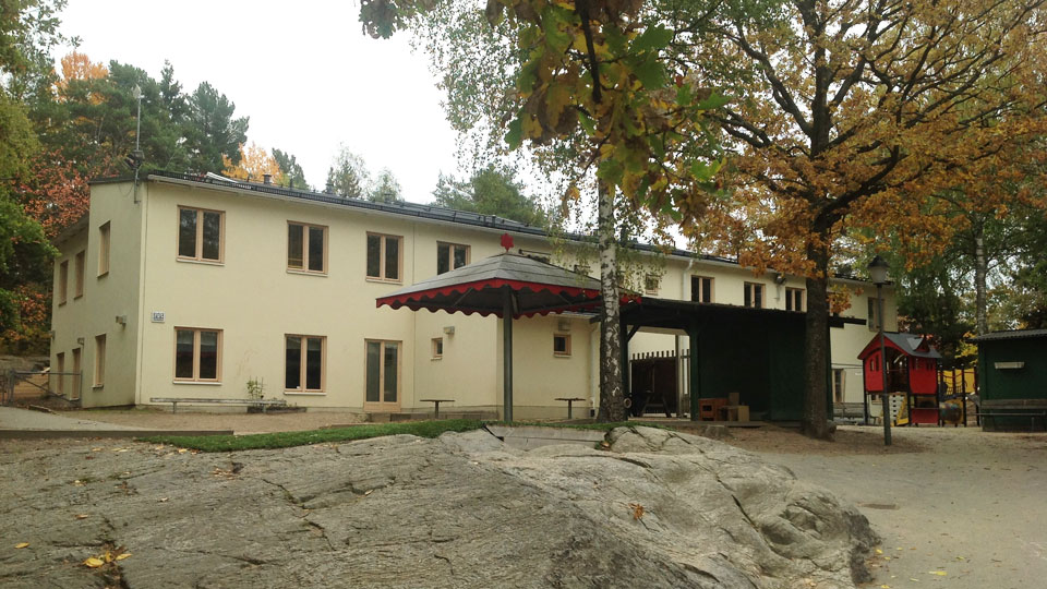 Förskolan Skogsbacken med förskolans naturgård framför.