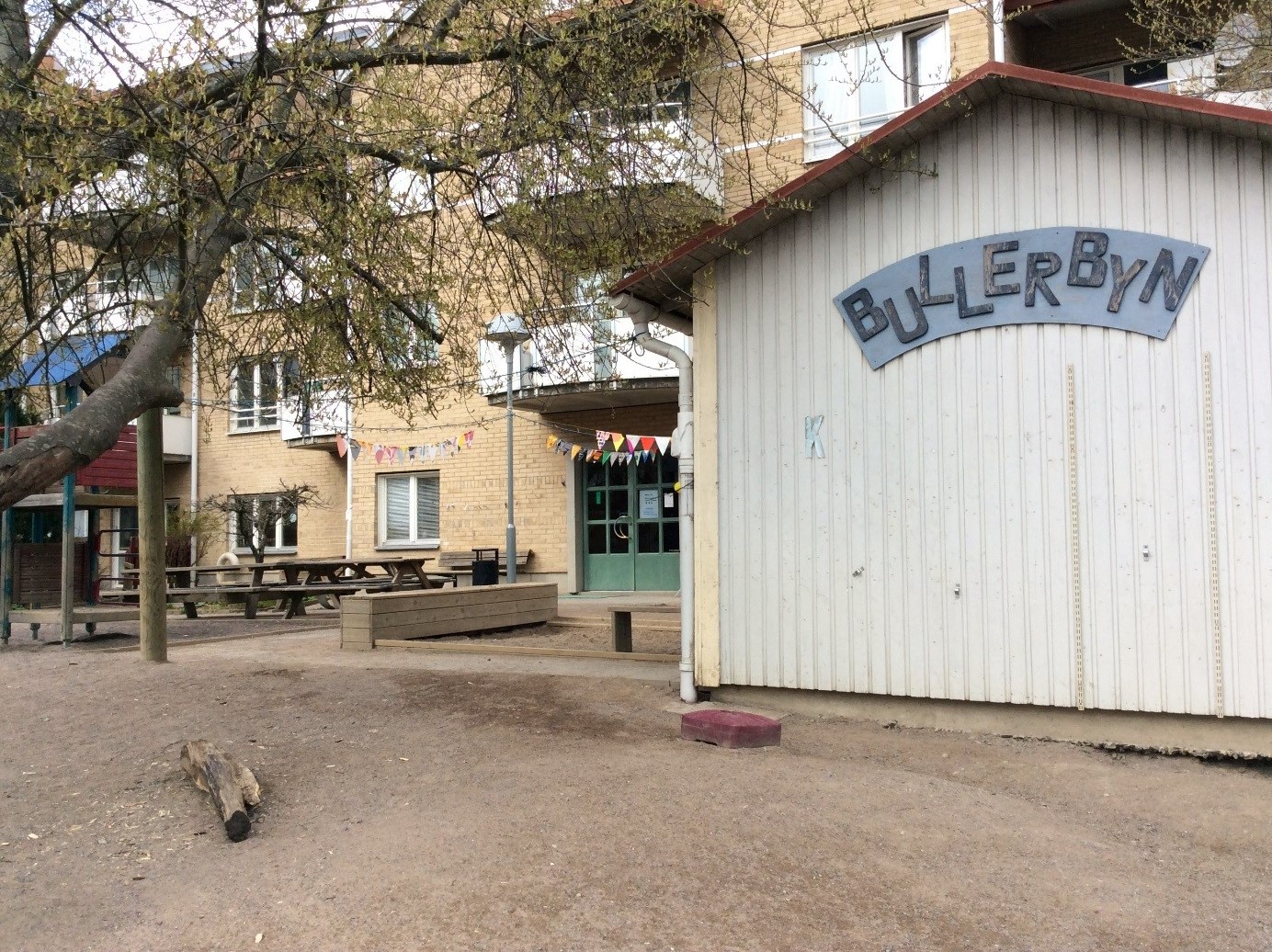 En del av förskolans lekplats med en skylt där det står Bullerbyn.