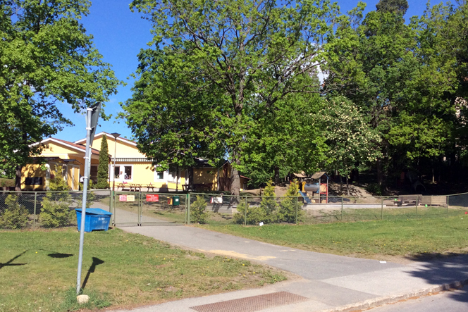 Ingången till förskolan Havsörnen. En grind som leder till en gul förskolbyggnad.