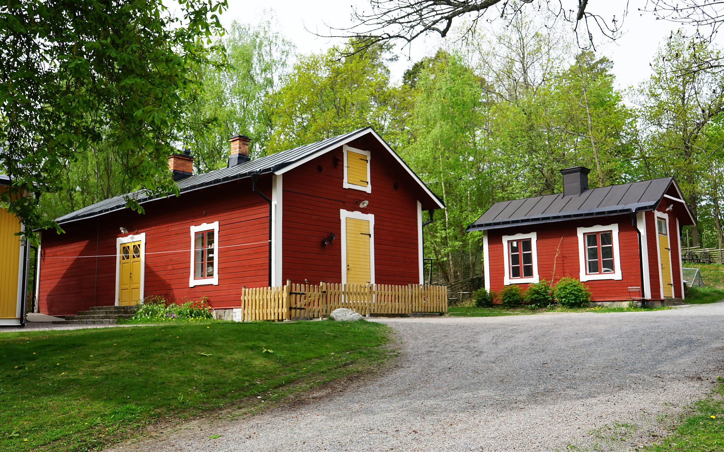 Röda trähus med gula dörrar.