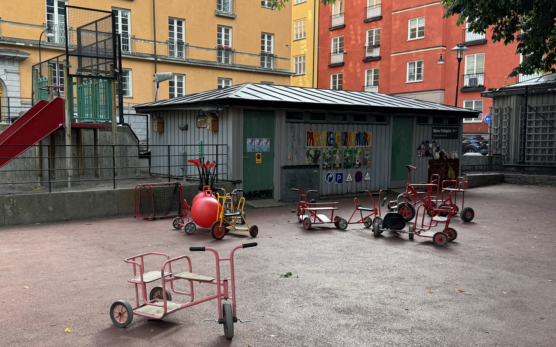 En förskolegård med många olika trehjuliga cyklar.