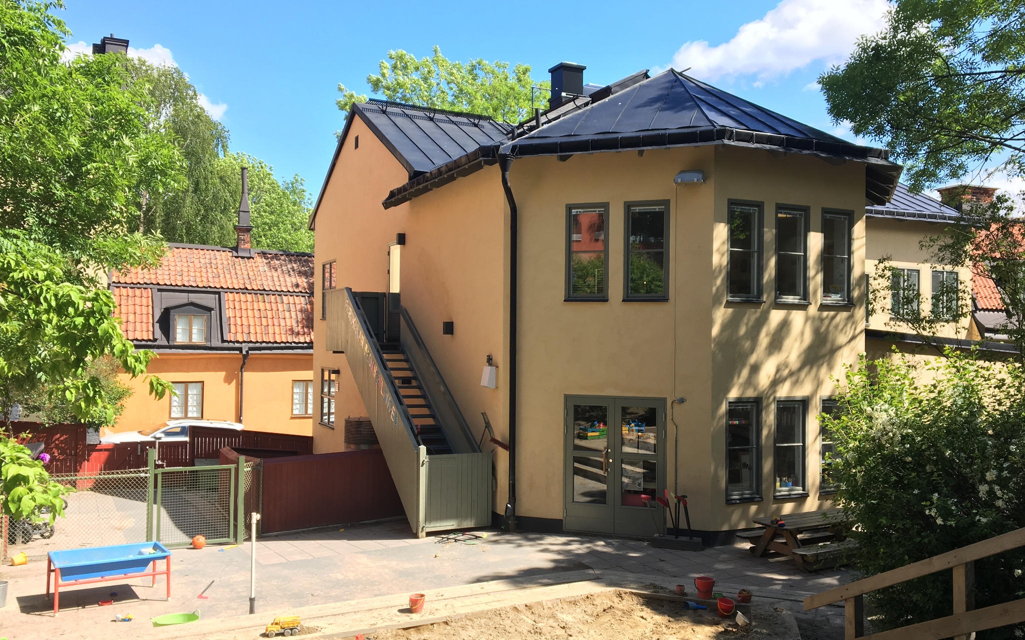 Sandlåda och lekredskap på Plommonlundens gård.