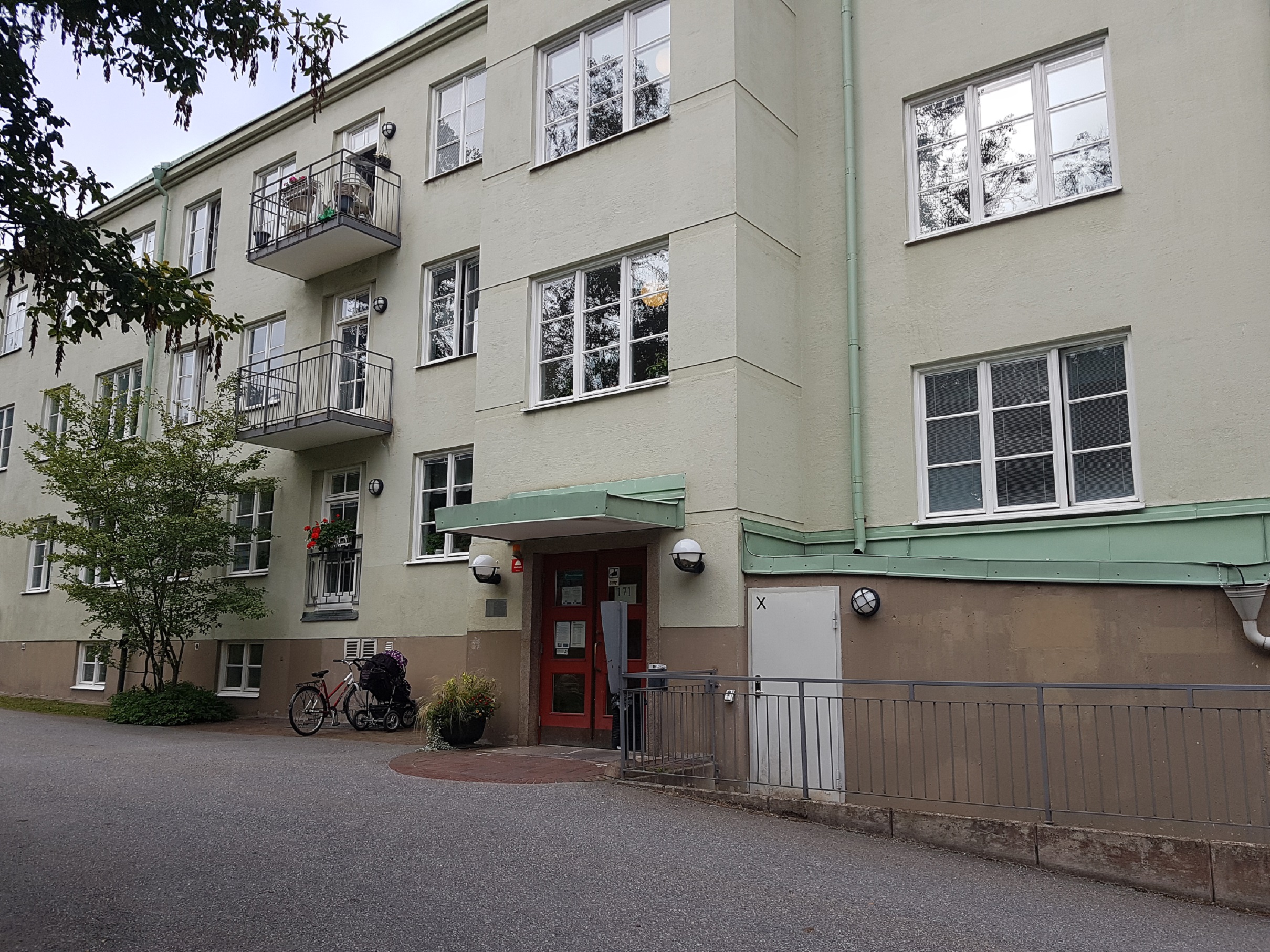 Fofografi, grönt trevåningshus med entré.