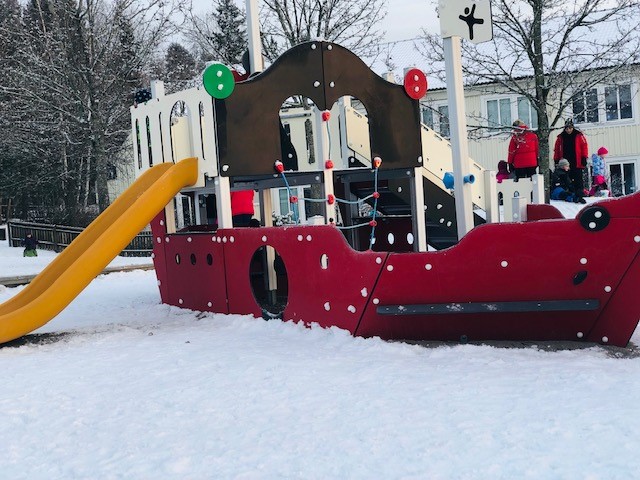 En lekplatsbåt med rutschkana på en lekplats.