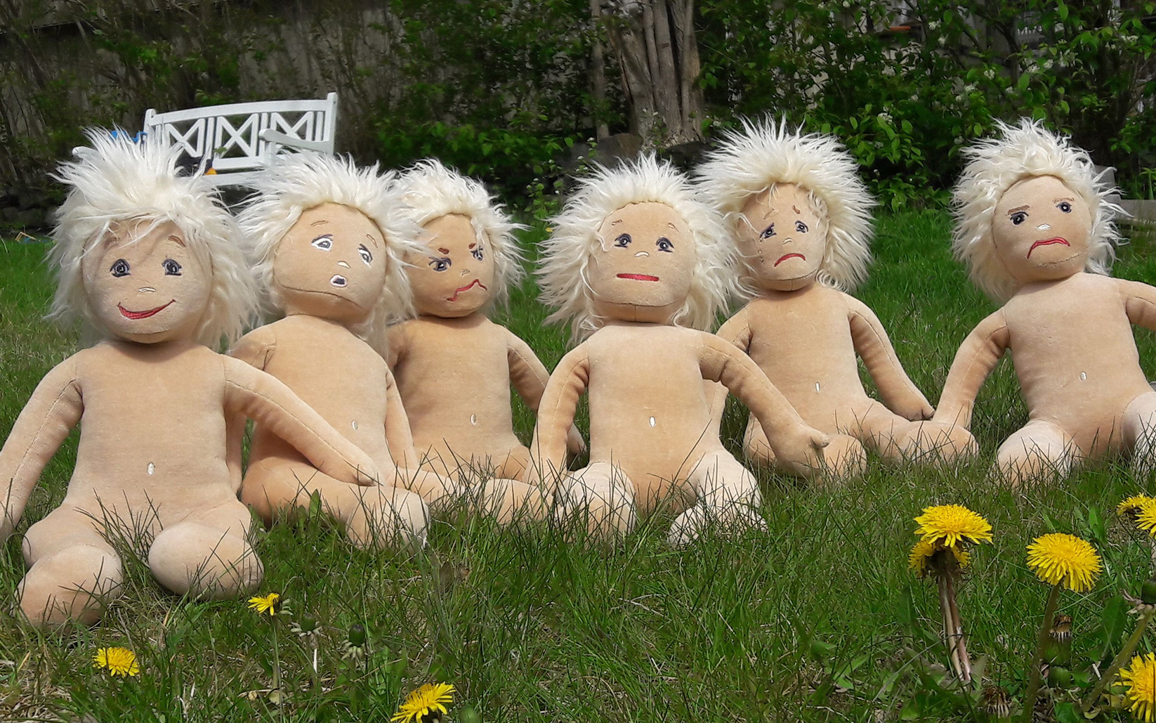 Dockor på gräsmatta, maskrosor.